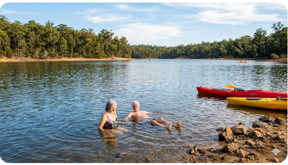 Grey nomads swimming and kayaking in the clear water at Glen Mervyn Dam near Collie Western Australia.