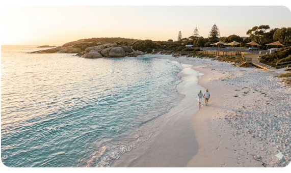 wilight Beach Esperance WA, white sand and turquoise waters at sunset, people walking along beach, shaded car park visible.